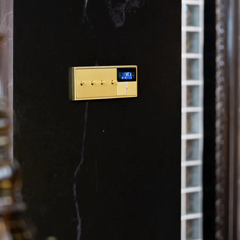 LS 1912 mit zylindrischem Kipphebel in Messing Classic und KNX F40 Taster, Detailaufnahme in leichter Perspektive, lediglich die Schalter sind fokussiert.