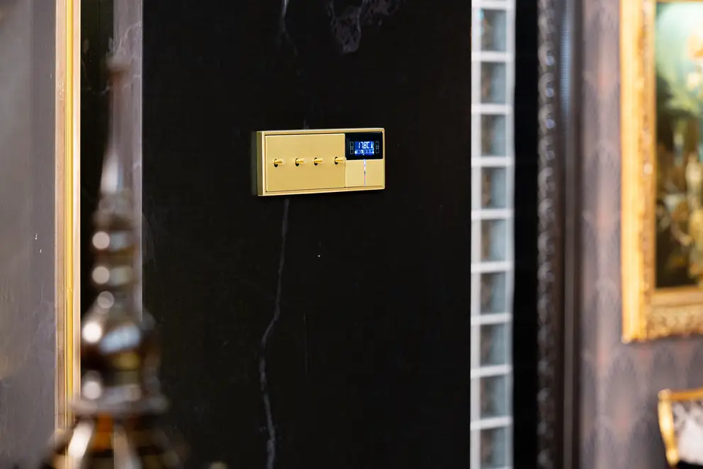 LS 1912 mit zylindrischem Kipphebel in Messing Classic und KNX F40 Taster, Detailaufnahme in leichter Perspektive, lediglich die Schalter sind fokussiert.